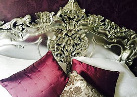 Purple bedroom with ornate headboard